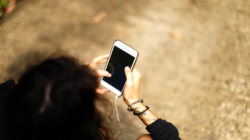 Elinde telefon tutan bir kişi